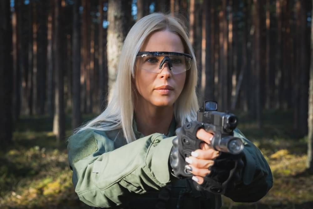 A girl wearing safety glasses in the woods